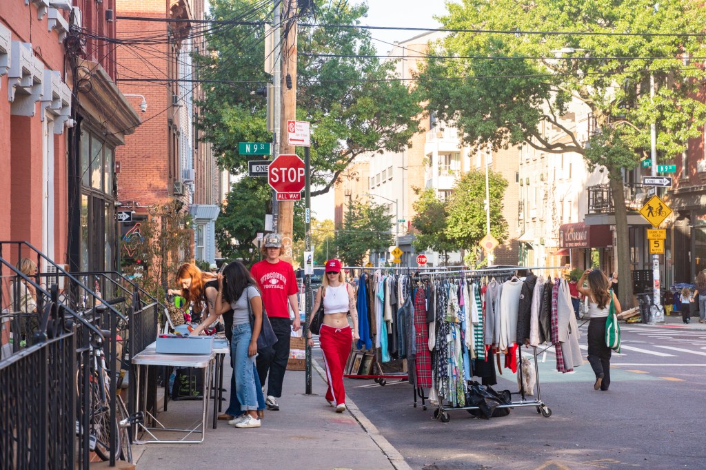 Sidewalk sale with people browsing along a street